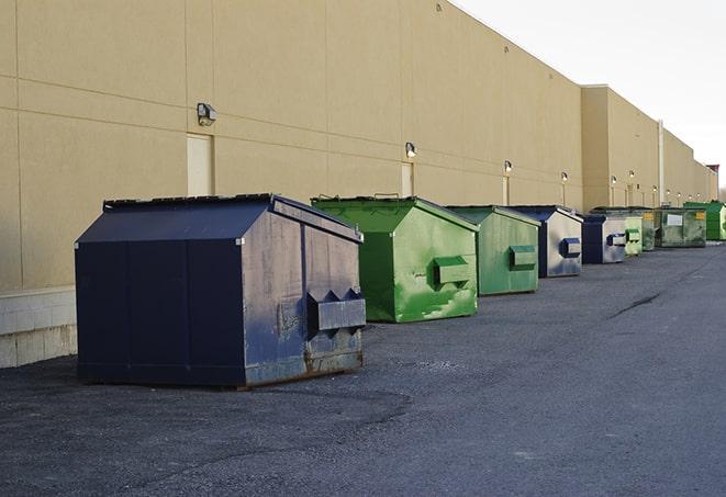 a compact construction dumpster being emptied by a waste disposal truck in Bristol RI